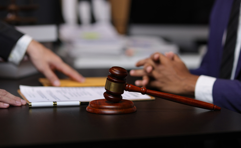 Lawyer reviewing contract agreement with legal documents, Discussing contract agreement at desk with legal document.
